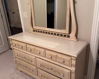 Beautiful off white dresser with mirror with painted flowers on drawers. In excellent condition and has matching side table.