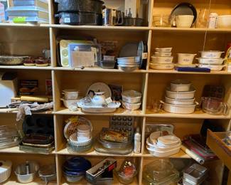 Shelves loaded with  kitchen wares.