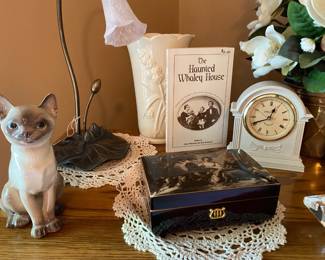 Siamese figurine, music box, bedside clock, and doilies.