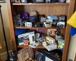 Bookcase full of cameras  - Canon, Nikon, Minolta, and more.
