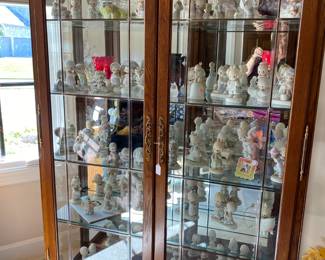 Beautiful glass display cabinet full of Precious Moments figurines.