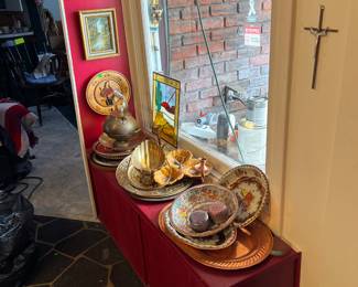 Metal platters, bowls, and plates along with wall decor