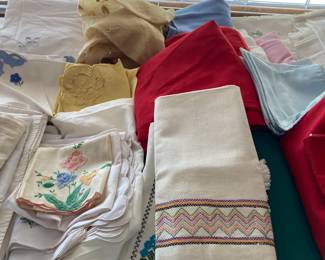 Lots of table linens-- tablecloths, napkins, table runners, and placemats