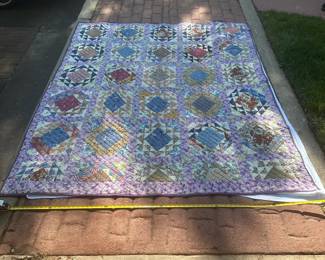 D63 - $125. GORGEOUS Purple Quilt in very good condition. There is some staining on the back side of the quilt. See Tape Measure on ground for an idea of size.