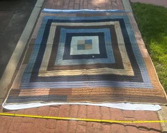 D59 - $95. Hand Pieced Quilt in earth tones. See Tape Measure on ground for an idea of size.