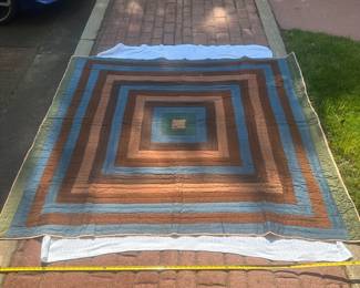 D58 - $95. Hand Pieced Quilt in earth tones. See Tape Measure on ground for an idea of size.
