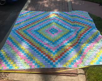 D64 - $100. Beautiful Homemade Quilt. Excellent Condition! See Tape Measure on ground for an idea of size.