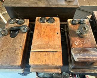Several wooden wall telephones all need repair