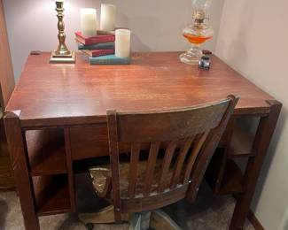 Dual sided desk with rolling chair, oil, lamp, brass table, lamps, vintage books, and battery candles