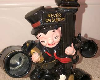 Vintage "Never on Sunday" decanter figurine of Charlie Chaplin as a hobo leaning on a lamppost with 3 shot glasses