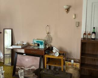 Vintage sewing machine, table, painting, suitcase, bookshelf.
