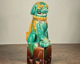 CHINESE FOO DOG CERAMIC FIGURE | Marked Hong Kong and with numbers. Green painted ceramic dog sitting on top of a brown pedestal. - h. 19 x d. 10 in