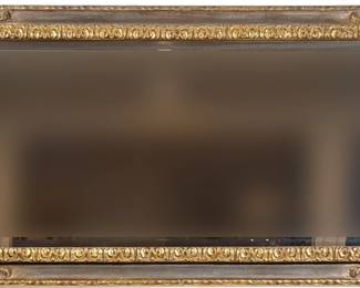 A FANCY CARVED GILT BEVELED LONG MIRROR | 19th/20th century; having a central aged mirror within a border of carved gilt wood, surrounded by panels of beveled glass with gilt carved scroll, vines, and acanthus leaves at the corners - could be hang vertically or horizontally as shown. - h. 35 x l. 67 in