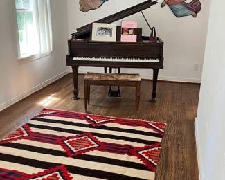 Antique metal angels from Guatemala, baby grand piano, large wool Zapotec rug.