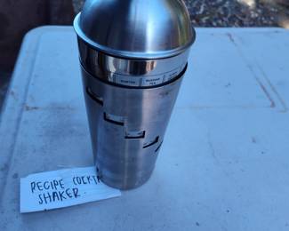 Cocktail shaker with recipes printed on the container by turning the outer sleeve