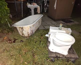 Claw-foot tub outside was painted several times, Toilet with a wall mount water tank and pedestal sink. Want a cute bathroom here's it is