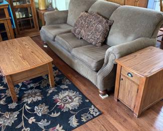 tan couch. oak formicah top coffee and entables, black rug