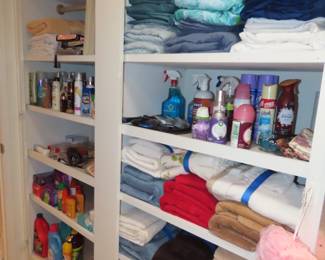 Shelves of personal hygiene items, towels, bed linens, cleaning supplies.