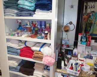 Shelves of personal hygiene items, towels, bed linens, cleaning supplies.