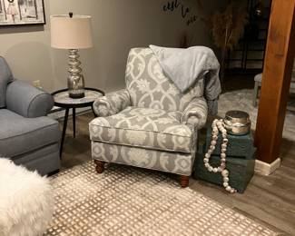 Upholstered, gray, and white chair And table and lamp and ottoman