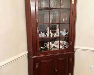 #18 - $1,000 - Henkel Harris corner cabinet mahogany 41x82x30D on the side wall. 18th century museum reproduction piece