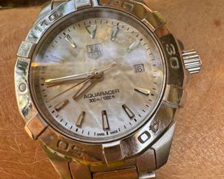 $750 - One ladies Tag Hauer stainless steel Aquaracer . Way 1412 - Serial RZE6771 - watch has mother of pearl dial, rotating bezel, sapphire crystal and the BA0920 stainless steel bracelet. Bere Appraisal included with your purchase.