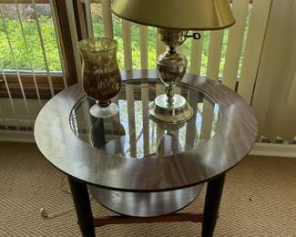 This is a lovely mid-century style table with a round shelf in the middle and a glass btop1