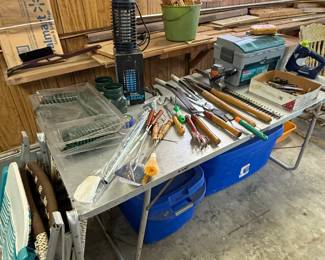 This table filled with lots of gardening outdoor and fishing supplies