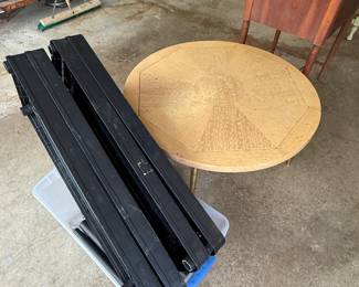 That’s a black shelf unit in the front and a beautiful mid-century modern table behind it. It could definitely use some TLC.