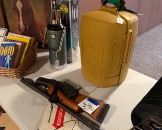 The gun in the table is in 20 different parts. There’s a stanley thermos in that yellow box right in the middle is a vintage Coleman lantern.