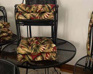several metal 4 seater tables with chairs and cushions