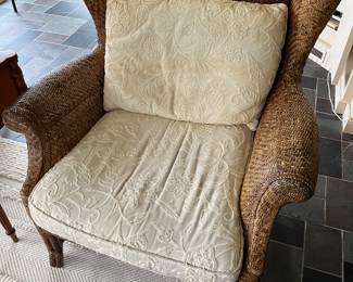 Closer view of one of two matching Baker Furniture “Milling Road” rattan chairs.