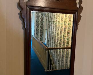 Antique mahogany-framed mirror with eagle motif.