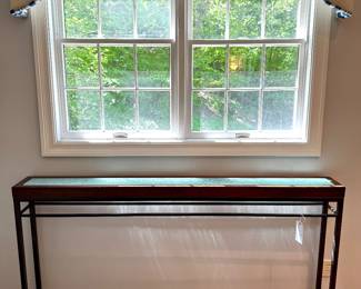 $400. Skinny, tall console table. Metal base. Crackle glass accented top. 70 x 8 x 39H. Made by Newhart.