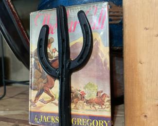2 iron horse shoe book stands, and old books