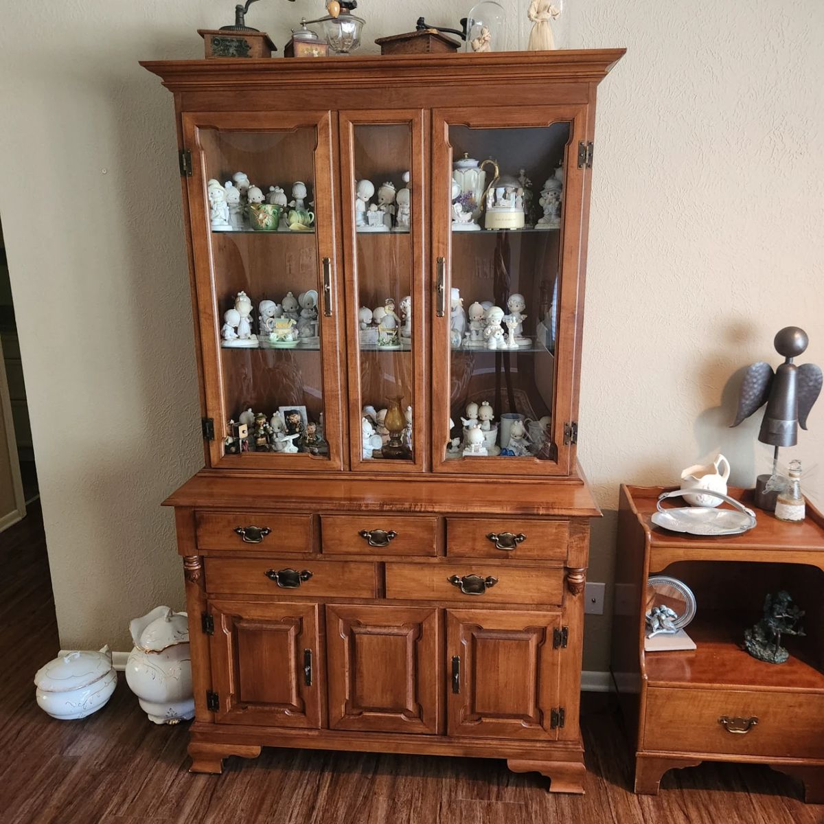 China cabinet filled with figurines, precious moments, and vintage wares