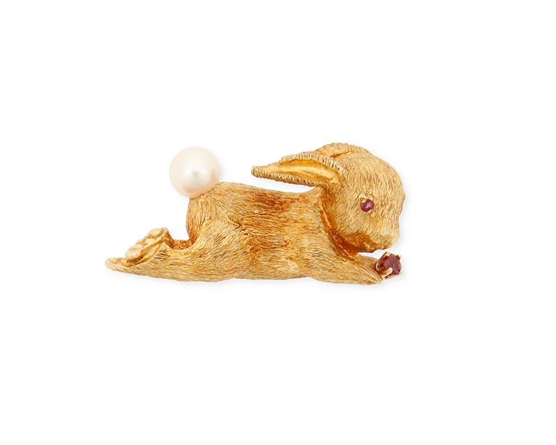 1001
Gumps: An 18K Gold, Ruby and Cultured Pearl Rabbit Brooch
Of a brushed rabbit design featuring a cultured pearl tail and two round ruby accents, signed with maker's mark
Measures: 1 3/8 in.
9.7 grams gross
Estimate: $400 - $600