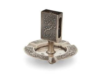 1170
Early 20th century
A Zee Wo & Co. Chinese Export silver matchbook and ashtray
Marked to underside: Zeewo; with illegible artisan mark
The sterling silver matchbook holder with metal striker mounted to central standard above an .800 silver ashtray, each depicting repoussé blossoms and bamboo motifs
Overall: 4" H x 4.375" Dia.
3.8 oz. troy approximately
Estimate: $150 - $250