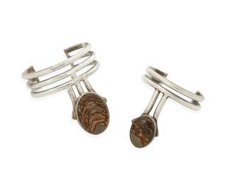 1121
Carl Chilstrom: Two Sterling Silver and Picture Jasper Cuff Bracelets
Comprising a three-wire modernist cuff with set picture jasper extension to center, as well as a similar design two-wire cuff, each signed and dated: Sept. 1975
2 pieces
Larger: 6 7/8 in. inner C x 2 7/8 in. H; smaller: 6 in. inner C x 2 1/2 in. H
126 grams gross
Estimate: $400 - $600