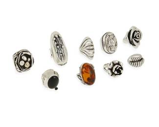 1119
A Group of Sterling Silver Rings
Four variously marked for sterling; two with makers marks: G [likely Samuel Greatwalker LaFountain, b. 1986, Diné/Chippewa] / JAC [with pictograph; possibly for John Carey of Eden Hand Arts]
Comprising nine silver rings in various styles and sizes including a large Marianne Johansson etched silver cocktail ring with two set opals to shoulders, a modernist Southwest sterling silver ring with set onyx, as well as two sterling silver flower rings, one marked: JAC, a set amber ring, three modernist style rings, and a large chunky silver "bird's nest" ring with silver and 10K gold eggs
9 pieces

Ring sizes: 6 to 8 1/2
192.4 grams gross
Estimate: $200 - $400