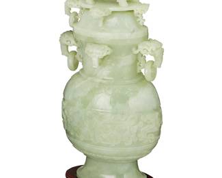 1164
20th century
A Chinese carved hardstone covered urn
The carved stone urn featuring high relief beast mask handles with rings, a guardian lion finial to lid, and chased taotie masks to the waist, set on a carved wood openwork stand
Urn: 16.75" H x 8" W x 5" D; Stand: 2" H x 7.75" W x 5.25" D
Estimate: $100 - $200