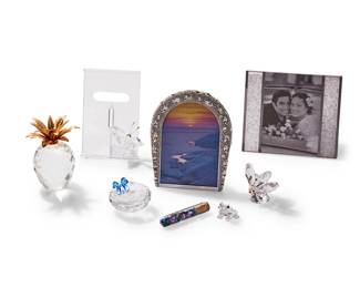 1131
Late 20th/early 21st century
A group of Swarovski glass table items
Each marked for Swarovski
Comprising an "Arcadia" frame housed in original box, a "Starlet" frame housed in original box, a butterfly frame housed in original box, a lidded box with blue and glass vile of cut-glass gems housed in original box, a butterfly figure with gilt-metal antennae, a pineapple with gilt-metal crown, and a frog figure, 7 pieces
Largest box: 3.75" H x 7.75" W x 7.75" D; Smallest figure: 1" H; Pineapple: 4.25" H
Estimate: $200 - $400
