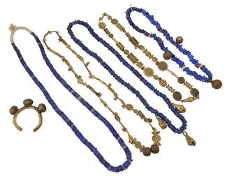1033
A Group of Vintage Blue Glass Trade Bead and Brass Jewelry
Late 19th/20th century
Comprising three single strand cobalt blue trade bead necklaces, two with brass bell accents, as well as an African brass cuff with bell ornaments, and two further brass bead necklaces, each with elaborate flat beads in various styles and sizes, 6 pieces
Largest: 39 in. L; smallest: 25 in. L; cuff: inner circumference 6 1/2 in. x 1 in. H; gap: 1 in.
960.9 grams gross
Estimate: $200 - $400