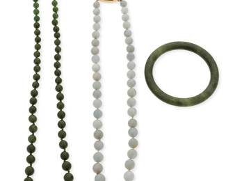 1020
A Group of Gold and Jade Jewelry
Including a graduated nephrite bead necklace finished with a 14k gold clasp, a graduated jade necklace finished with a 14k gold and carved jade clasp and a carved jade bangle
3 pieces
Bracelet: 7 1/2 in, Necklaces: 23 in., 19 in.
158.2 grams gross
Estimate: $600 - $800
