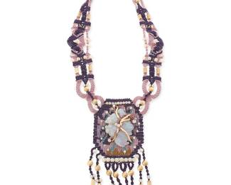1098
Barbara Natoli Witt: A Cavandoli Macramé and Carved Opal Necklace
With elaborate knotwork in purple, lilac, and tan cord, featuring a carved opal stone fish plaque and opal and 14k gold beads and beaded fringe, circa 1974, signed and dated to ceramic bead
36 in. x 6.5 in.
60.6 grams gross
Estimate: $1,000 - $2,000
