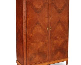 1142
20th century
A Neoclassical-style armoire
The wood armoire featuring book-matched burlwood veneer to front and sides and inlaid border accents, each locking cabinet door with brass wreath-form pulls revealing four shelves, surmounted by an architectural cornice and raised on tapered feet
79.5" H x 52.5" W x 20.75" D
Estimate: $400 - $600