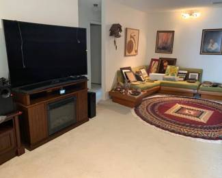 Curved large screen TV, New fireplace and cabinet set, stereo equipmebt, frames, artwork, clocks, rug