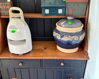 Left is a wireless outdoor speaker, on the right is stoneware with the lid, in Waynes coating style kitchen pantry cabinet.