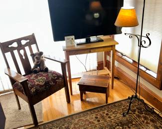 Arts and Crafts chair on the left, jointed teddy bear, flat screen TV, side table, foot stool and wrought iron floor lamp. NOTE - the area rug.