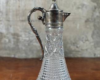 This lot features an antique Leonard Italian crystal and silver plate decanter. This silver plate crystal decanter made in Italy measures, 12” H x 5” W x 5” D. Leonard, the brand, is known for both its crystal and silver-plated items, and its history is linked to the Leonard Silver Manufacturing Company and later, Towle Silversmiths. Leonard products are often designed by Towle but produced and sold by other companies, often under the Leonard name. The brand is known for offering affordable luxury items that look expensive. Marked, “Made in Italy” as shown in photos.
